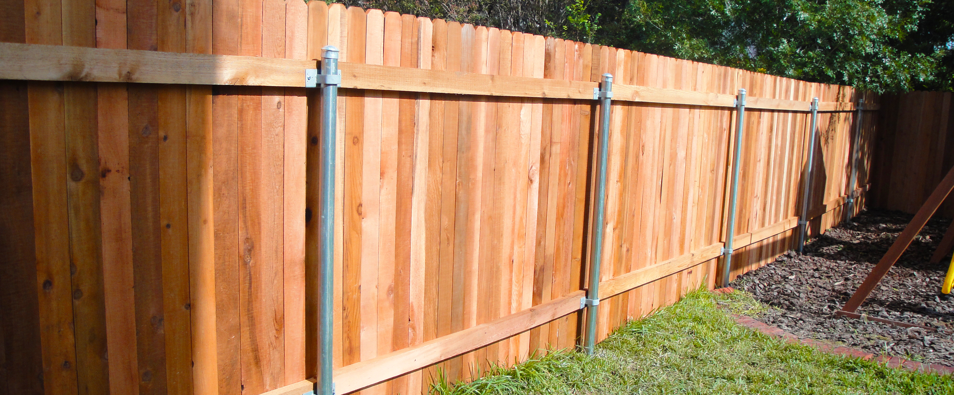 Wooden backyard fence with steel posts