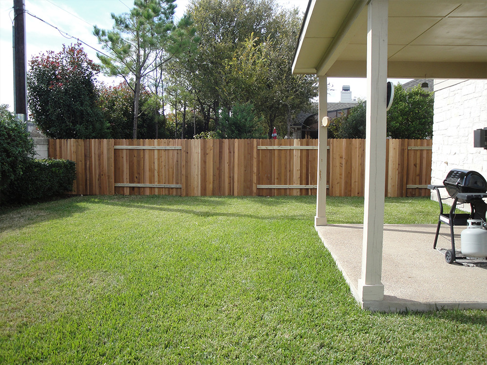 Wooden fence in the lawn behind a house