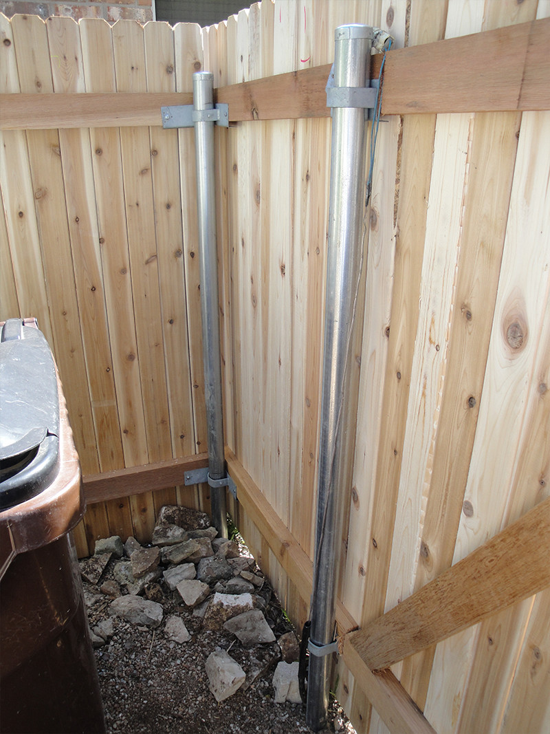 Wooden fence with steel posts in the corner of a yard