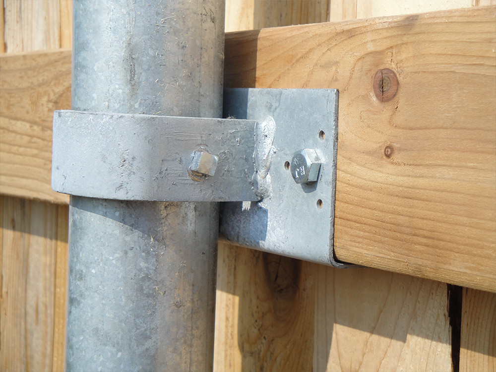 Closeup of steel post screws on a wooden fence