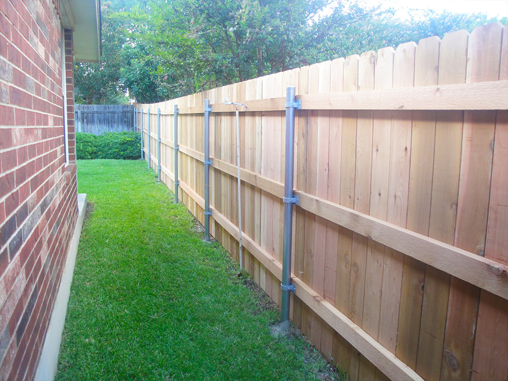 Wooden fence with steel posts on the side of a house