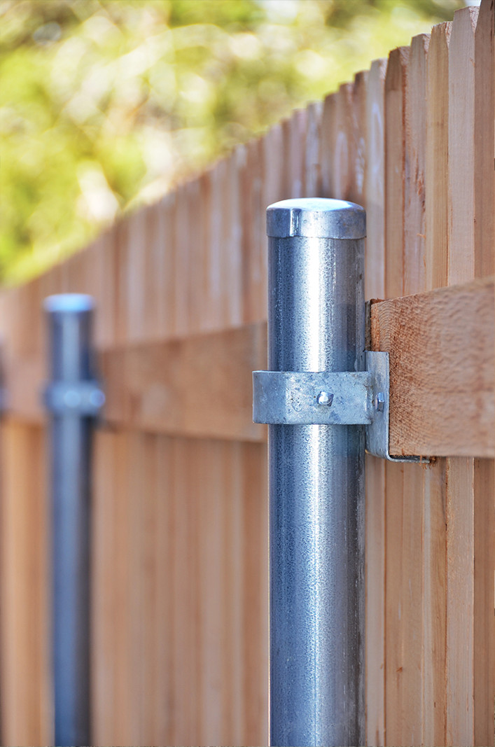 Closeup of steel posts on a wooden fence