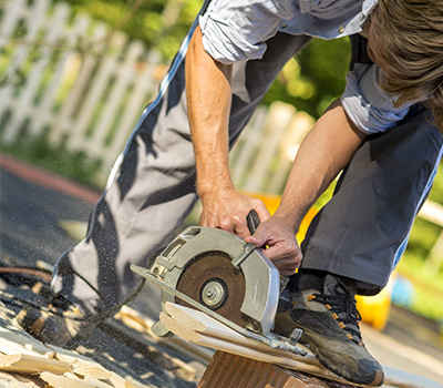 man cutting fence planks